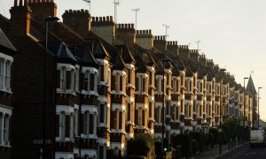 Row of attached houses on a street. Grey sky.