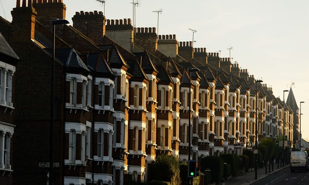 Row of attached houses on a street. Grey sky.