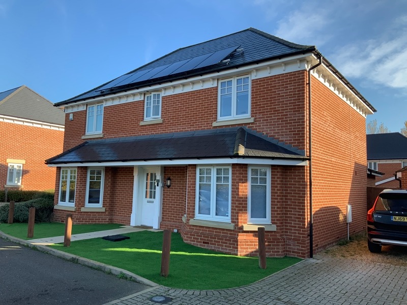 new build house with a volvo parked on the drive