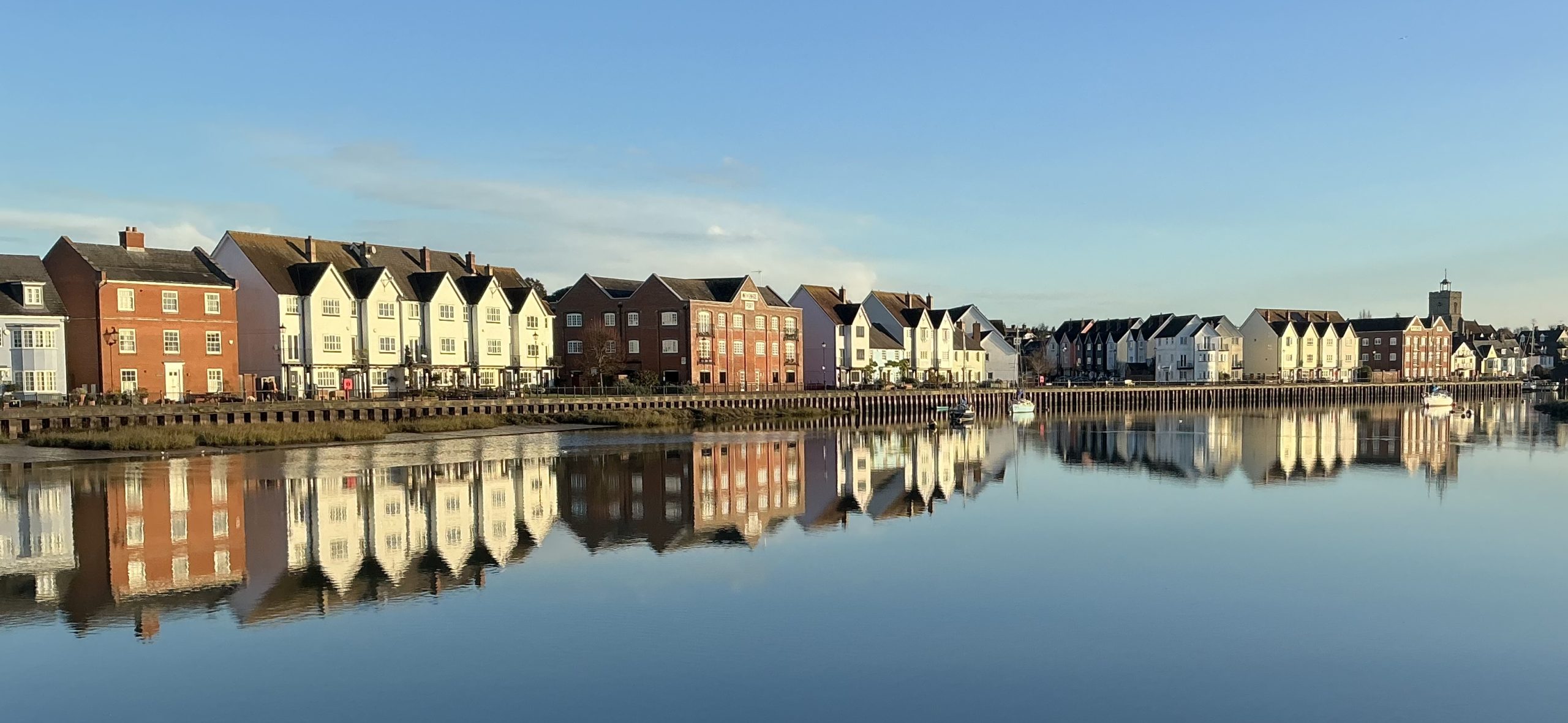 Body of water in front of row of houses
