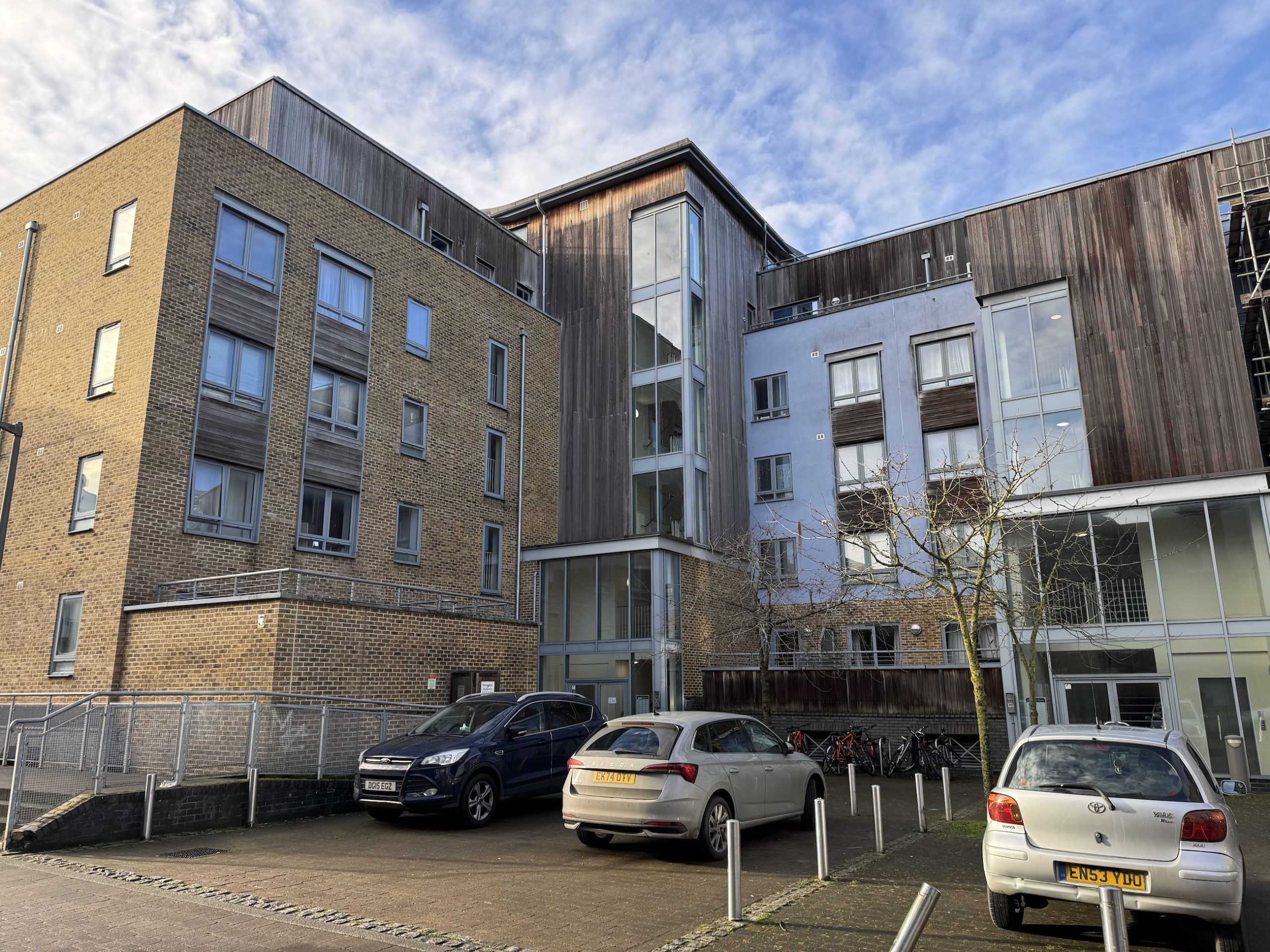 wooden paneled flats with cars in front