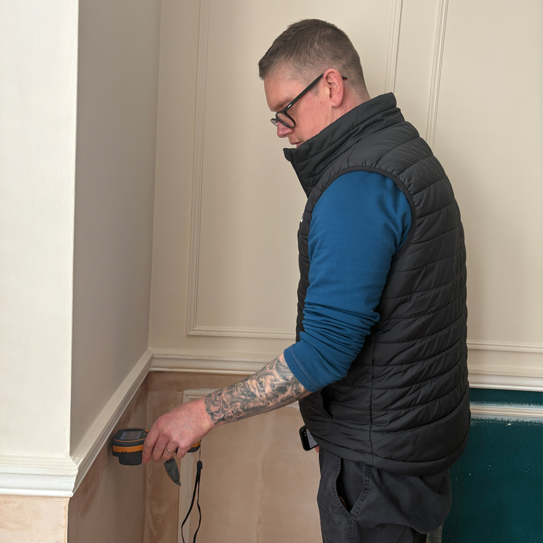 Surveyor doing a damp test on an internal wall